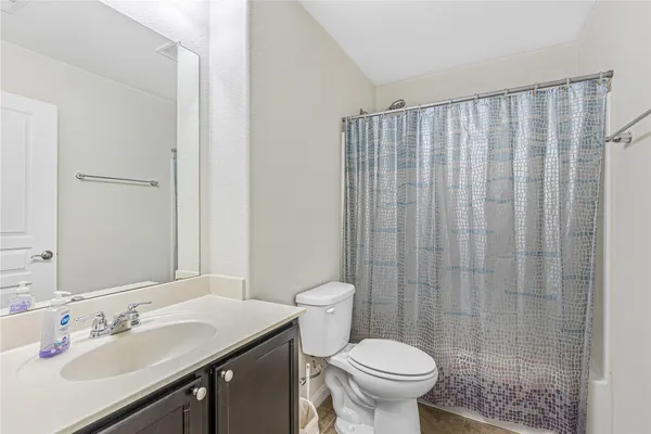 a bathroom with a granite countertop sink a toilet and a mirror