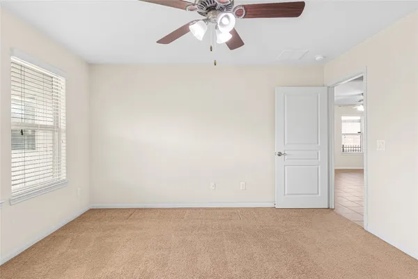 an empty room with chandelier fan