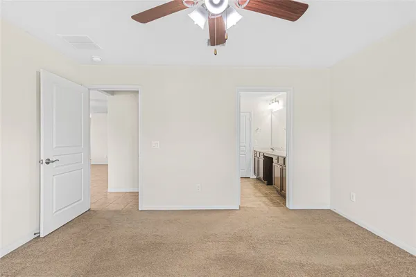 an empty room with chandelier fan