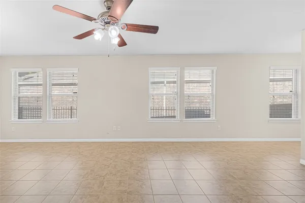 an empty room with fan and windows