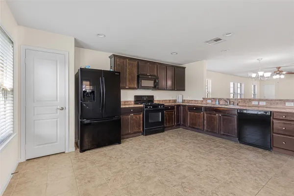 a kitchen with stainless steel appliances granite countertop a refrigerator and a stove
