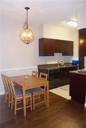 a kitchen with stainless steel appliances granite countertop a sink dishwasher and a stove with wooden floor