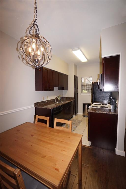 203 East 31st Street, Unit 103 Austin, TX 78705 - Photo 13 of 32 a kitchen with stainless steel appliances granite countertop a sink dishwasher and a stove with wooden floor