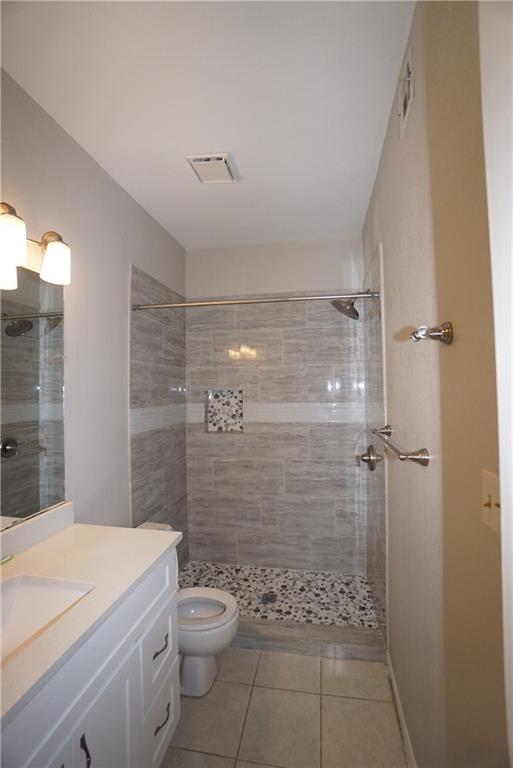 203 East 31st Street, Unit 103 Austin, TX 78705 - Photo 20 of 32 a bathroom with a granite countertop toilet a sink a shower and mirror