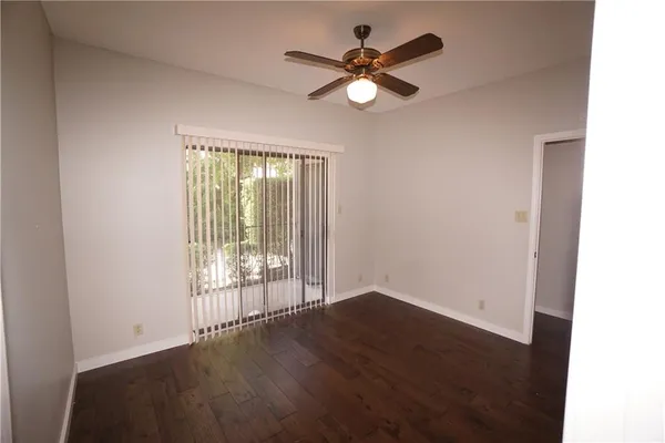 a view of wooden floor and a chandelier fan in a room