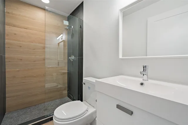 a bathroom with a sink a toilet and shower