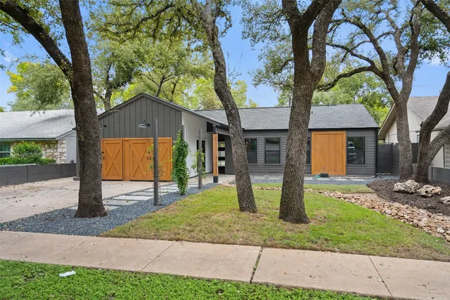 a front view of a house with a yard and tree