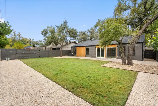 a white house with a large pool of the house in front of it