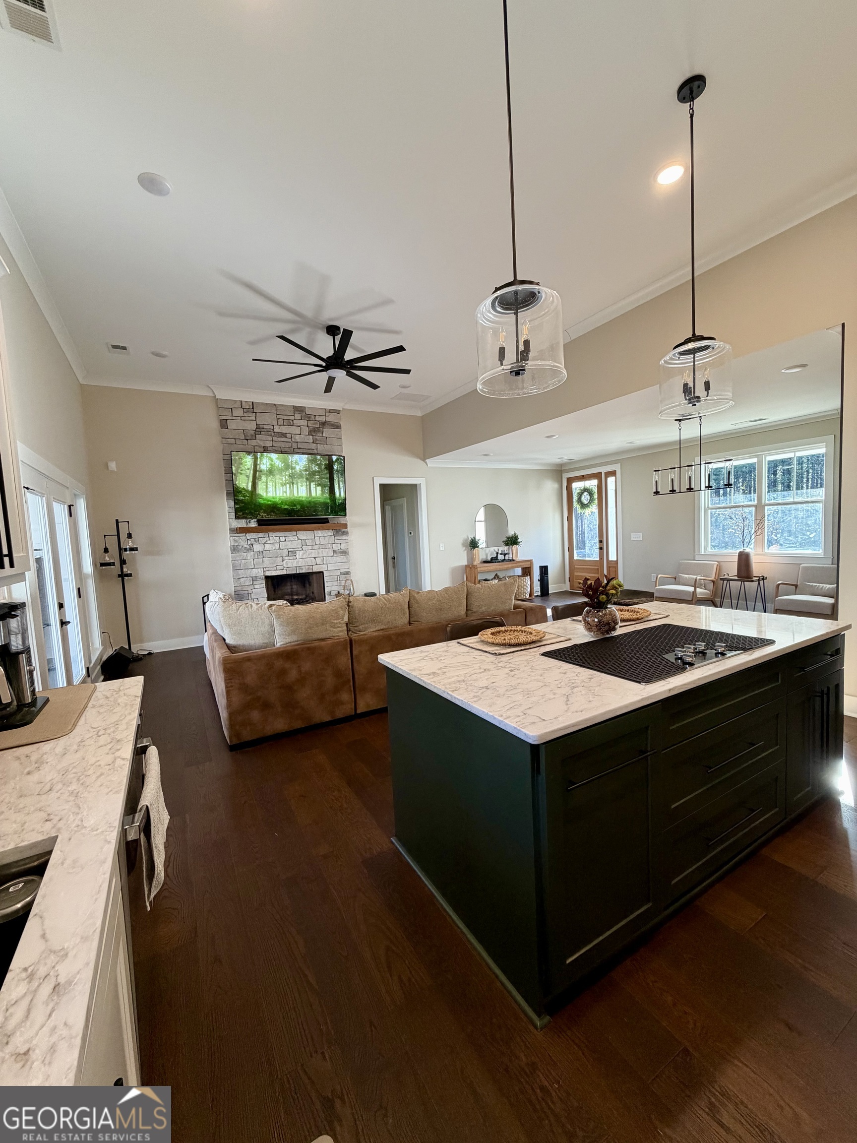3050 Mahlon Smith Road Social Circle, GA 30025 - Photo 13 of 37 a living room with furniture a chandelier and a dining table with wooden floor