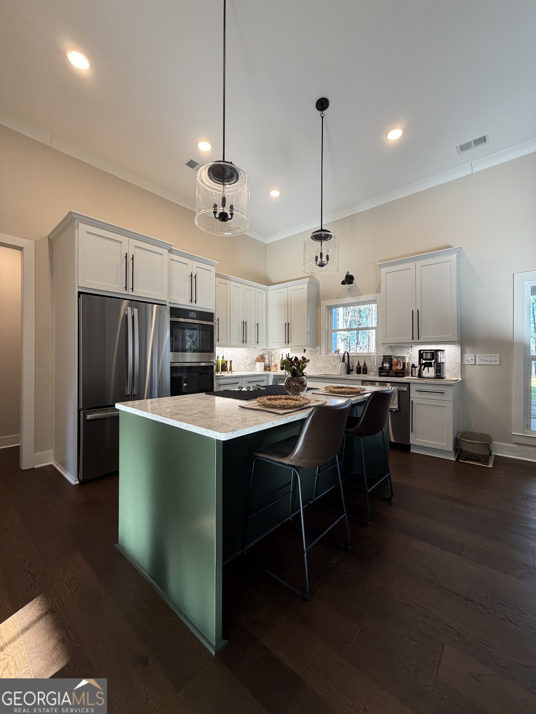 3050 Mahlon Smith Road Social Circle, GA 30025 - Photo 9 of 37 a kitchen with stainless steel appliances kitchen island a refrigerator and a sink