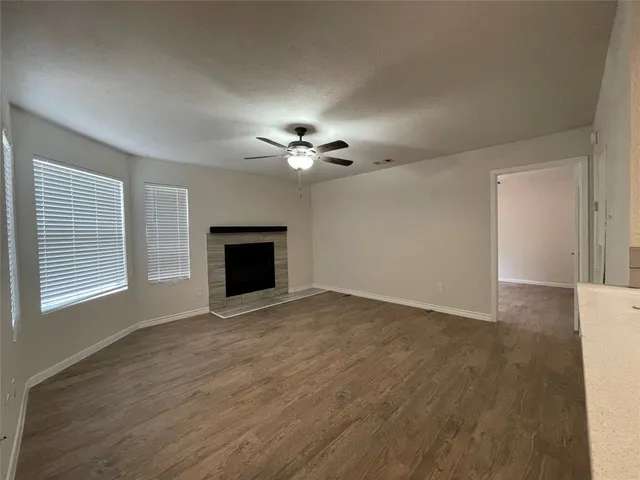 a view of an empty room with a fireplace and a window