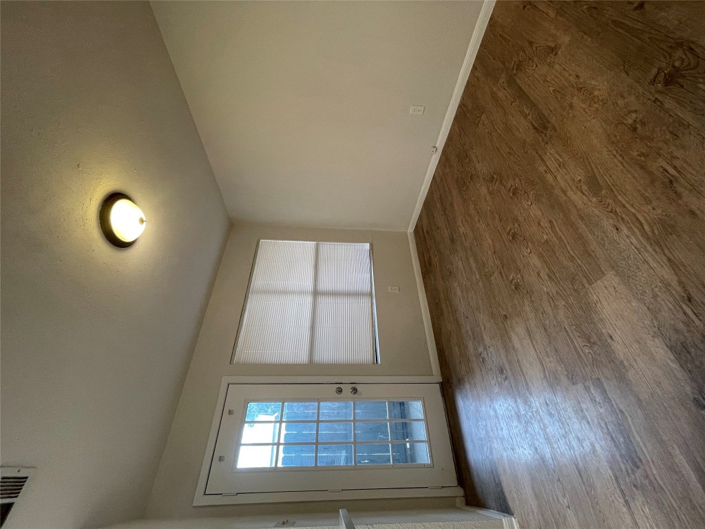 8806 Schick Road, Unit A Austin, TX 78729 - Photo 7 of 13 an empty room with wooden floor and windows