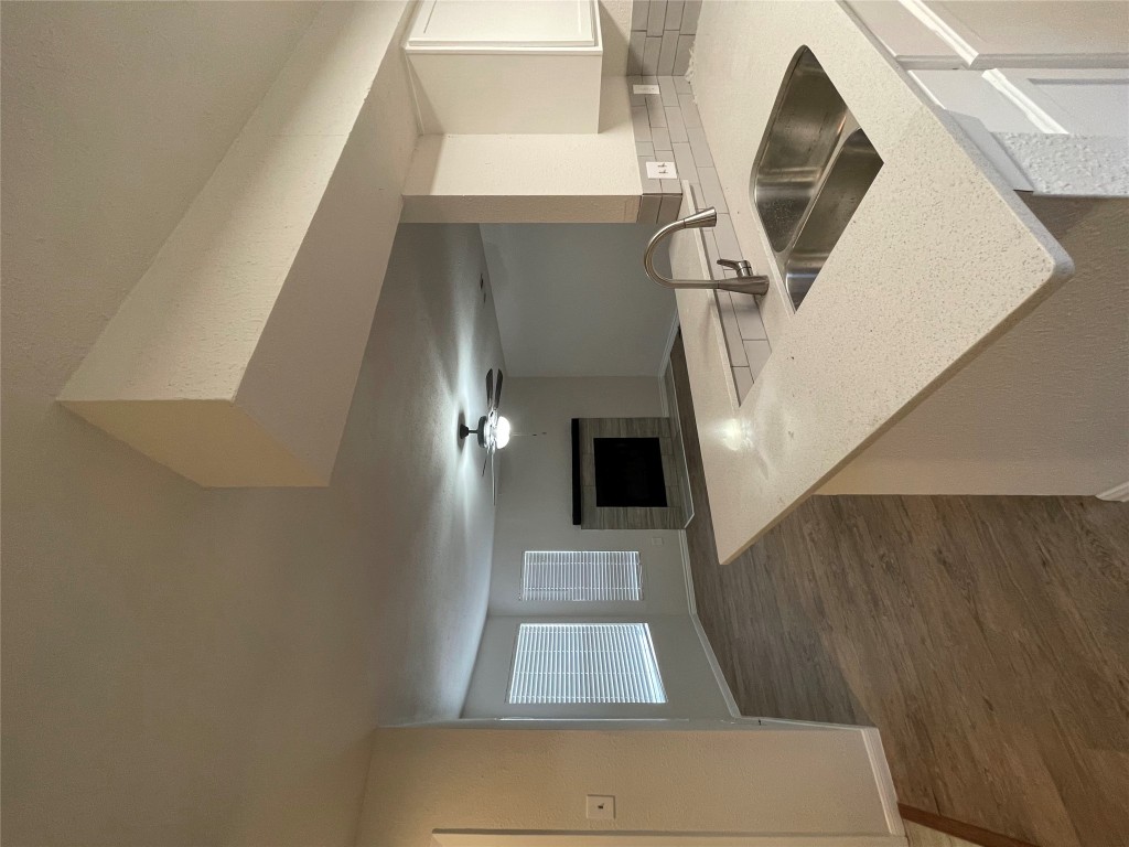 8806 Schick Road, Unit A Austin, TX 78729 - Photo 8 of 13 a kitchen with granite countertop a sink and a stove top oven with wooden floor