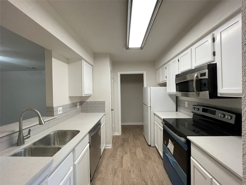 8806 Schick Road, Unit A Austin, TX 78729 - Photo 9 of 13 a kitchen with a sink stove top oven and refrigerator