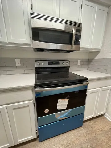 a stove top oven sitting inside of a kitchen