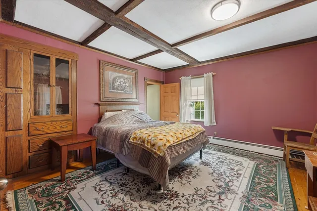 a bedroom with a bed dresser and a window