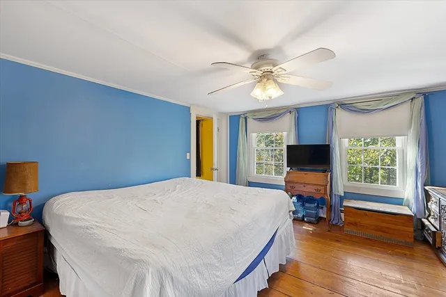 a bedroom with a bed television and a window