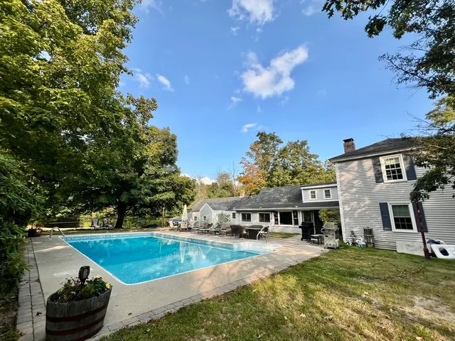 a view of a house with swimming pool and yard