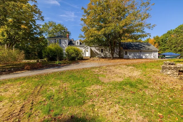 a view of swimming pool with lawn chairs and plants