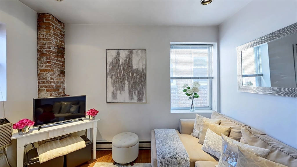 91 Prince Street, Unit 18 Boston, MA 02113 - Photo 2 of 13 a living room with furniture a flat screen tv and a window