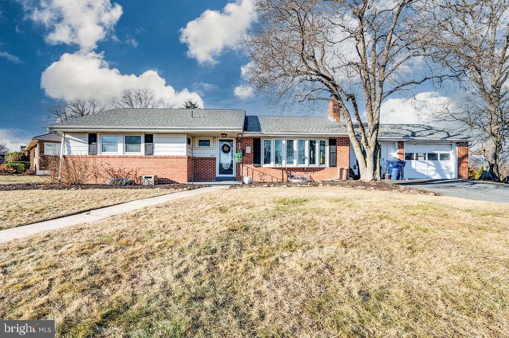 a view of large house with a yard covered in snow