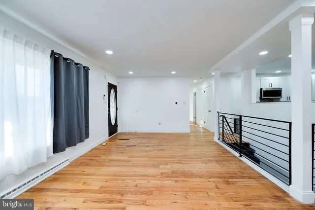 a view of a kitchen with wooden floor and a fireplace