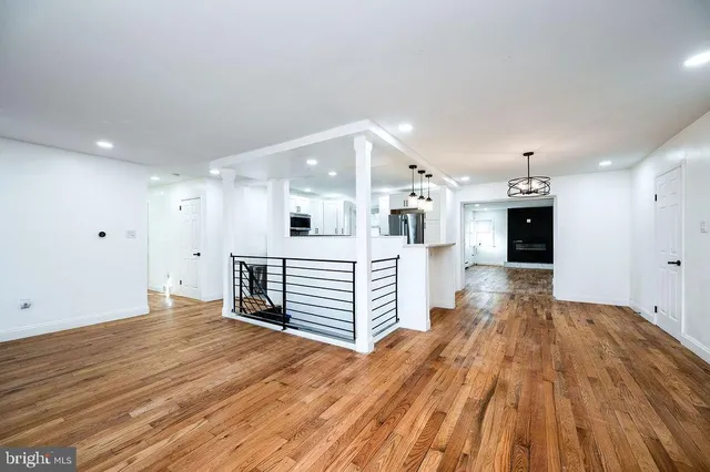 a view of a hallway with wooden floor and windows