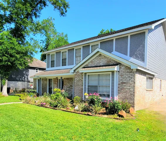 a front view of a house with a yard and trees