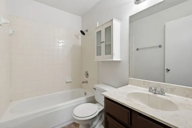 a bathroom with a granite countertop sink toilet and shower