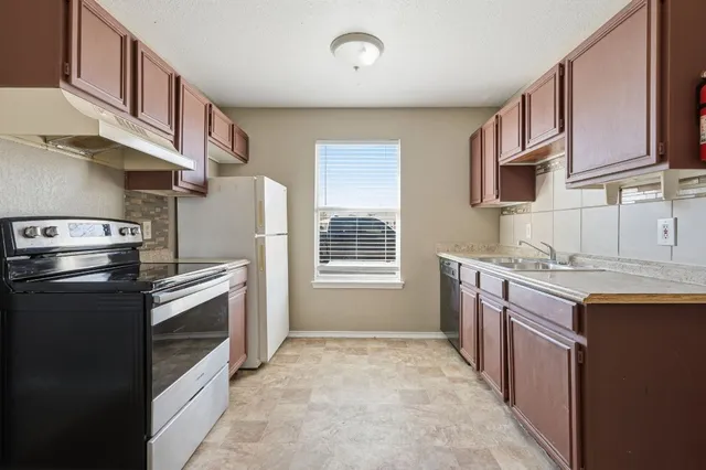 a kitchen with a stove sink and refrigerator
