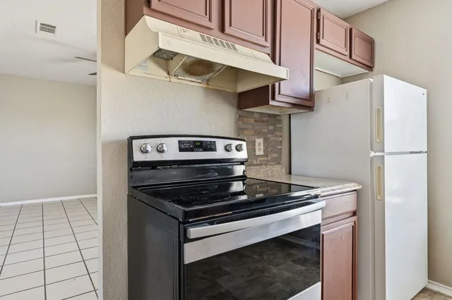 a kitchen with stainless steel appliances granite countertop a stove and a refrigerator