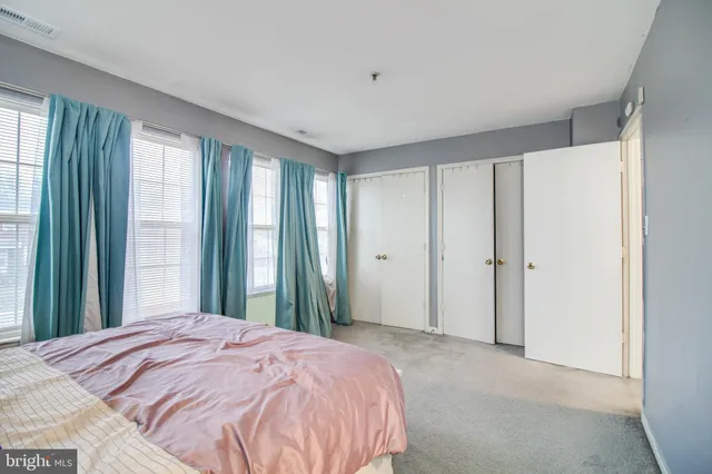 a bed sitting in a bedroom next to a window and a bathroom