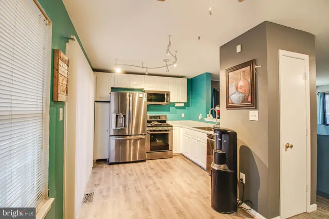 a kitchen with stainless steel appliances granite countertop a refrigerator and a stove top oven