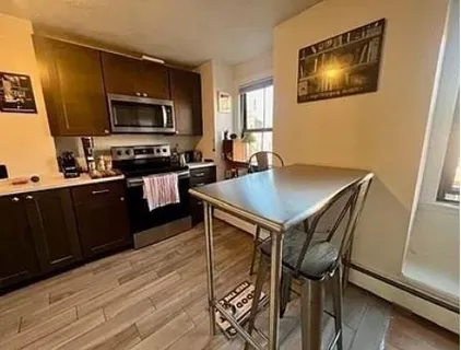 a kitchen with a table chairs refrigerator and microwave