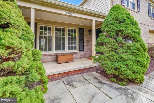 a front view of a house with a yard and potted plants