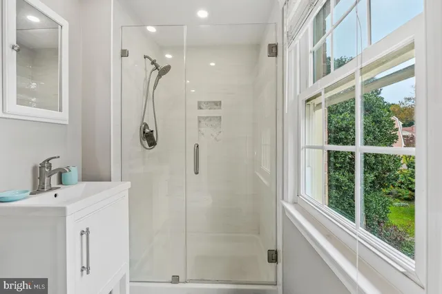a bathroom with a shower sink and mirror