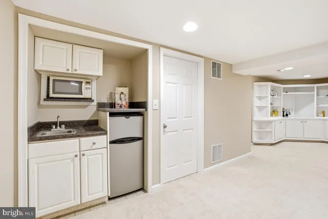 a kitchen with granite countertop a sink stove and refrigerator