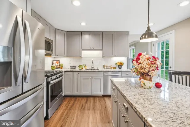 a kitchen with granite countertop a sink stove and refrigerator