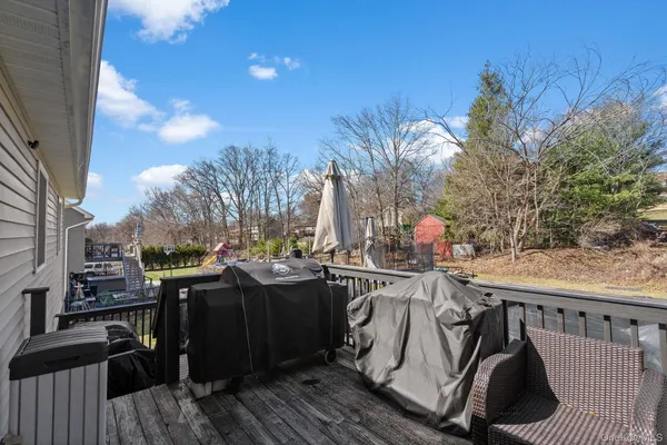 a view of a roof deck with chair and wooden floor