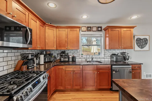 a kitchen with stainless steel appliances a stove a sink dishwasher and cabinets with wooden floor