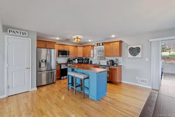 a kitchen with stainless steel appliances granite countertop a refrigerator a stove and a wooden floors