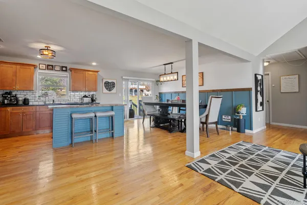 a living room filled with furniture and kitchen view