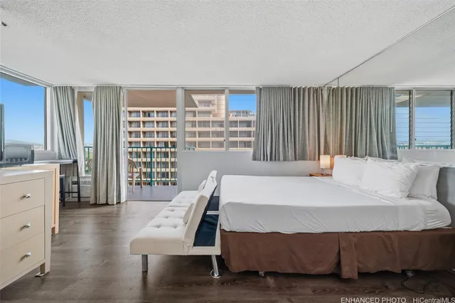 a bedroom with a bed a bookshelf and a large window