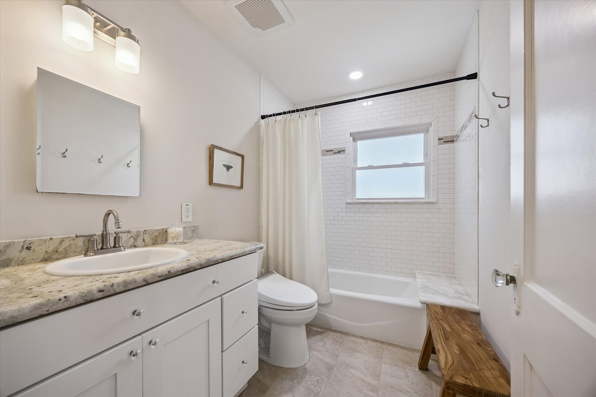 809 Gale Street Houston, TX 77009 - Photo 12 of 18 Fresh, neutral bathroom with a granite topped vanity, subway tiled tub and shower surround.