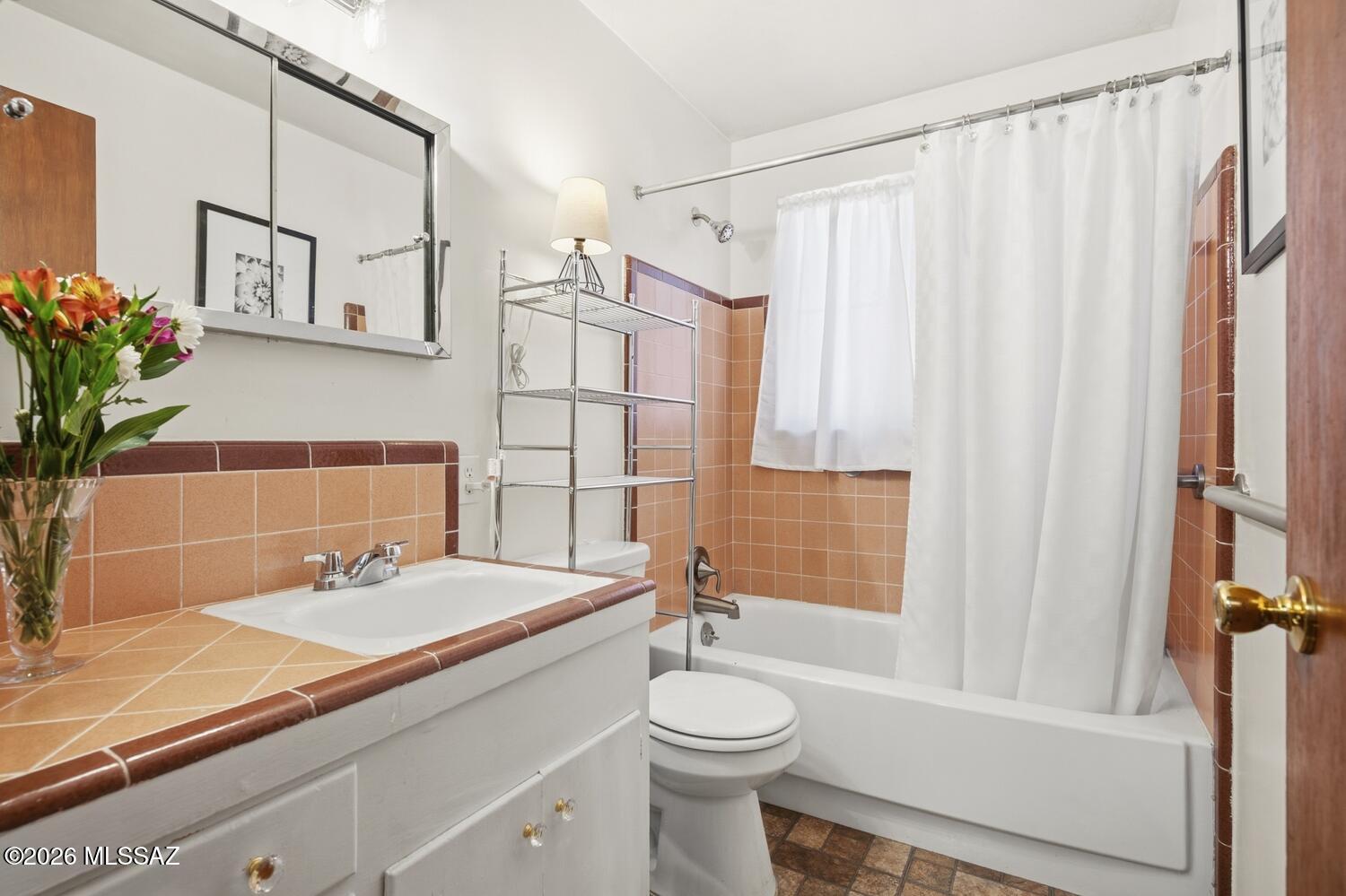 336 East 24th Street Tucson, AZ 85713 - Photo 18 of 27 a bathroom with a sink a toilet and shower curtain