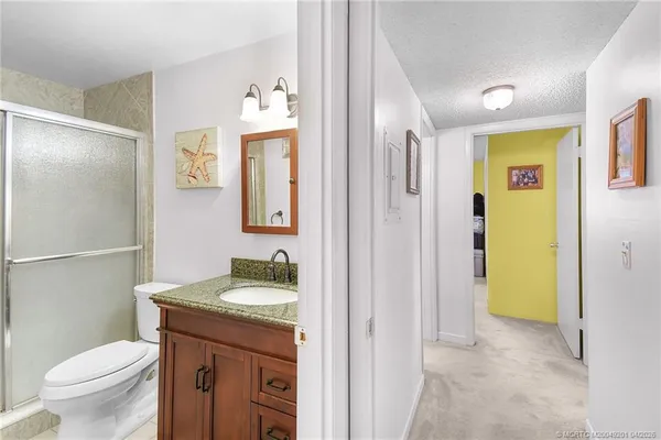 a bathroom with a granite countertop sink toilet and shower