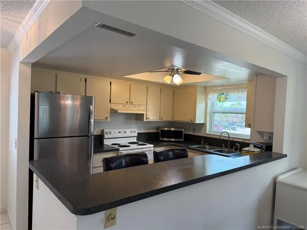 a kitchen with stainless steel appliances granite countertop a refrigerator a sink and a stove