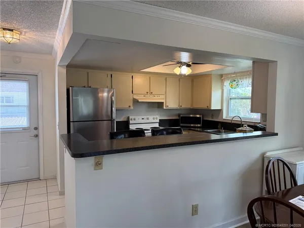 a kitchen with stainless steel appliances granite countertop a refrigerator a sink and a stove