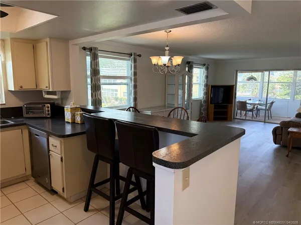 a kitchen with granite countertop a sink and chairs
