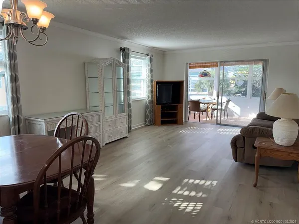 a dining room with furniture a chandelier and wooden floor